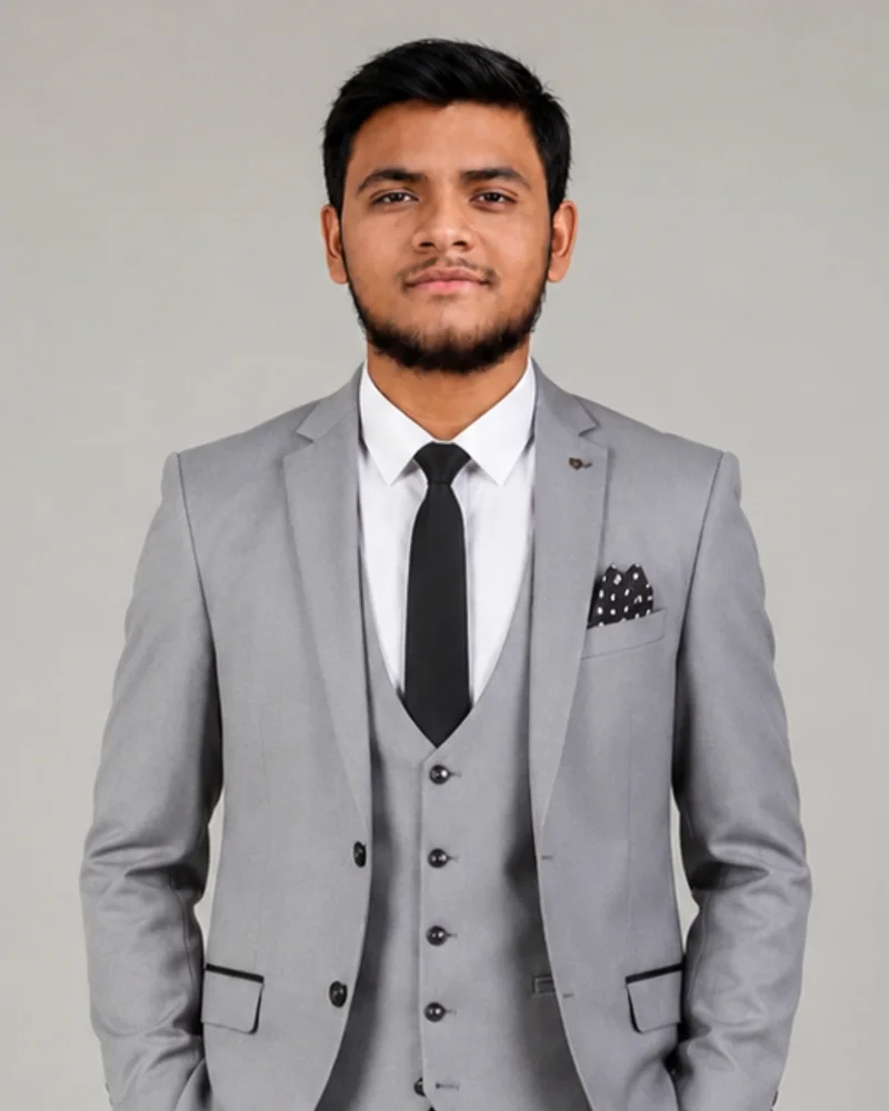 Portrait of Abdur Razzak Jiwani wearing a grey three-piece suit over a white shirt and black tie